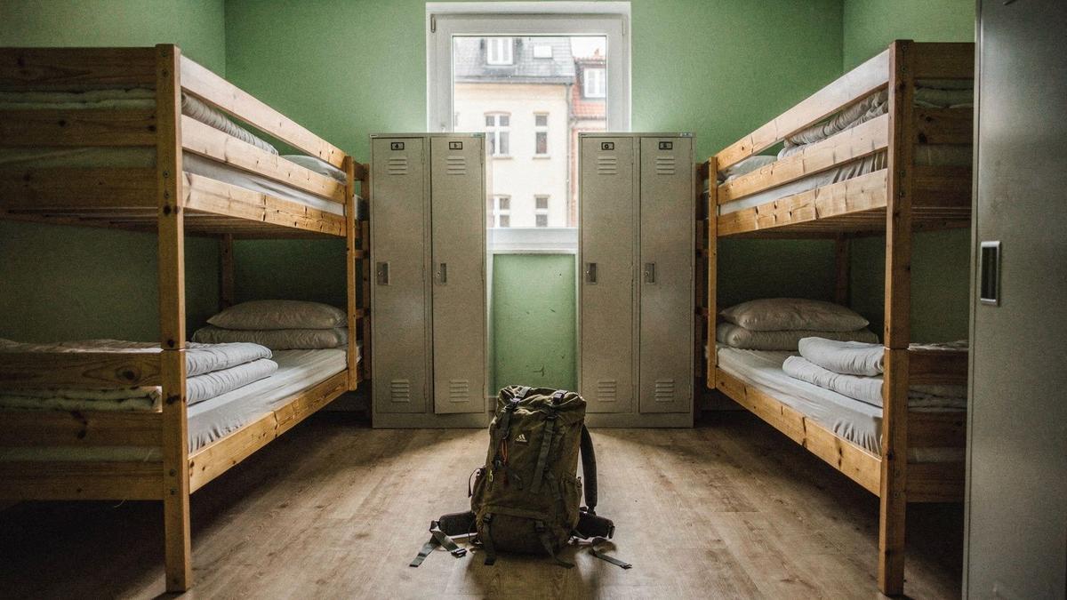 Six-bed hostel dormitory with wooden bunk beds and lockers on a student tour